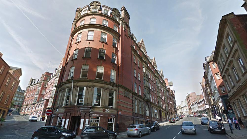 Exterior of Milburn House, a six-story Baroque-style office building with a red brick façade