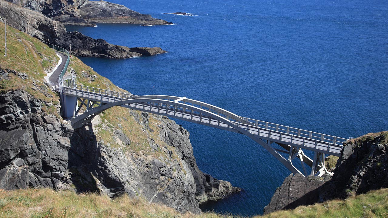 High level view of Mizen Head arched footbridge, spanning a sea gorge, looking out to sea