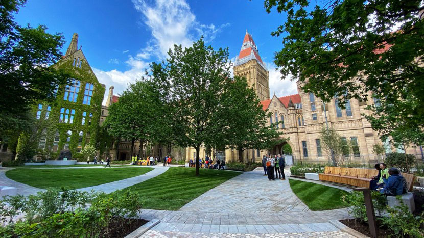 Green lawned area with historic gothic buildings on two sides