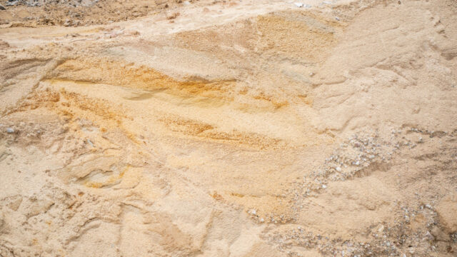 Aerial view of a development site with rough sand and rocks