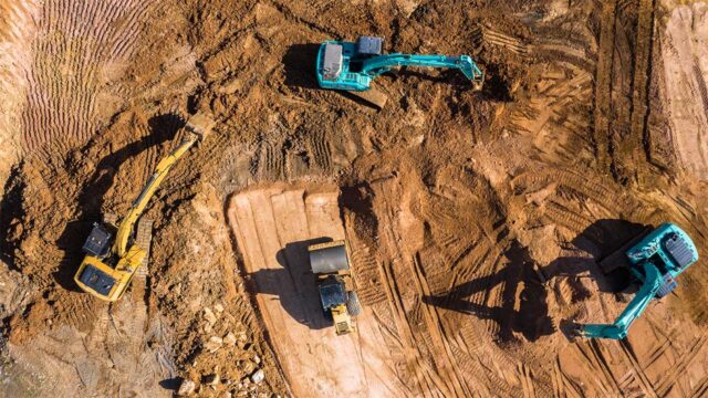 Aerial view of construction diggers working on an area of cleared earth