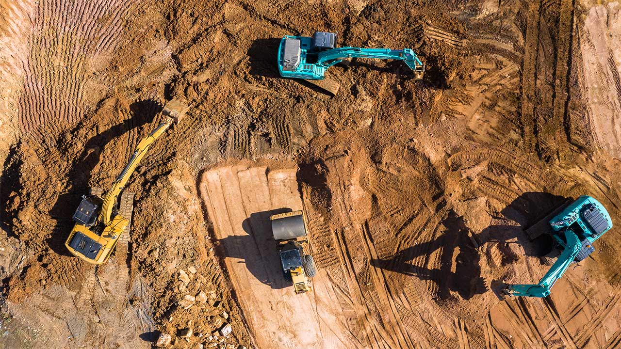 Aerial view of construction diggers working on an area of cleared earth