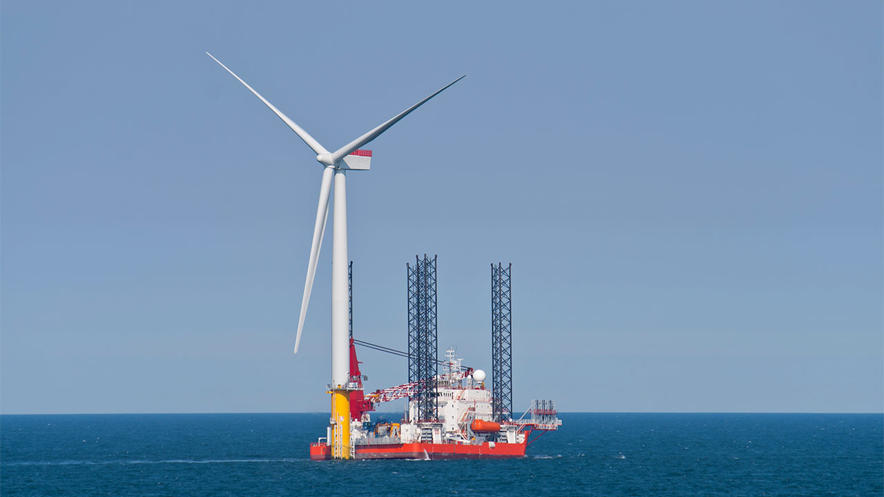 Image of an offshore wind turbine under construction, surrounded by sea