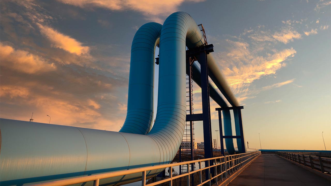 Closeup of an oil pipeline with the sunset in the background