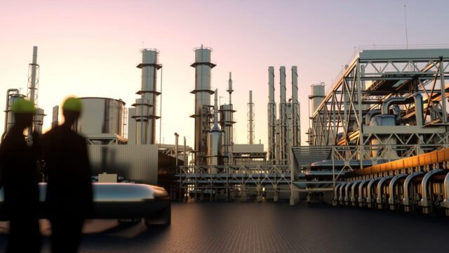 Silhouetted workers in hard hats overlook a large industrial refinery with towers, pipes, and storage tanks