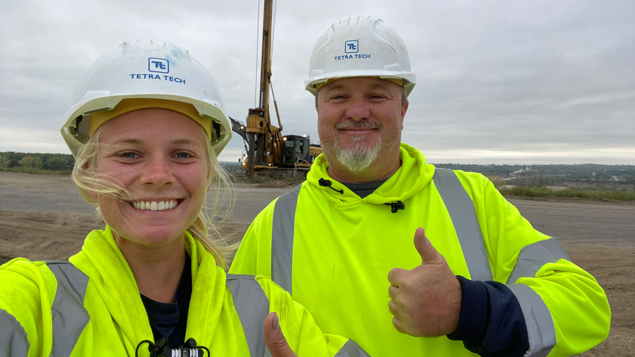 Tetra Tech field team pose by a drill rig at an active project site