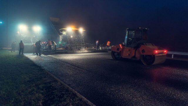 Nightworkers working on street with heavy machinery
