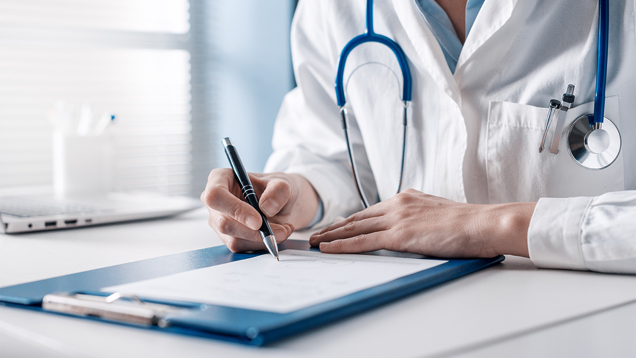 Medical professional filling out a form on a clipboard