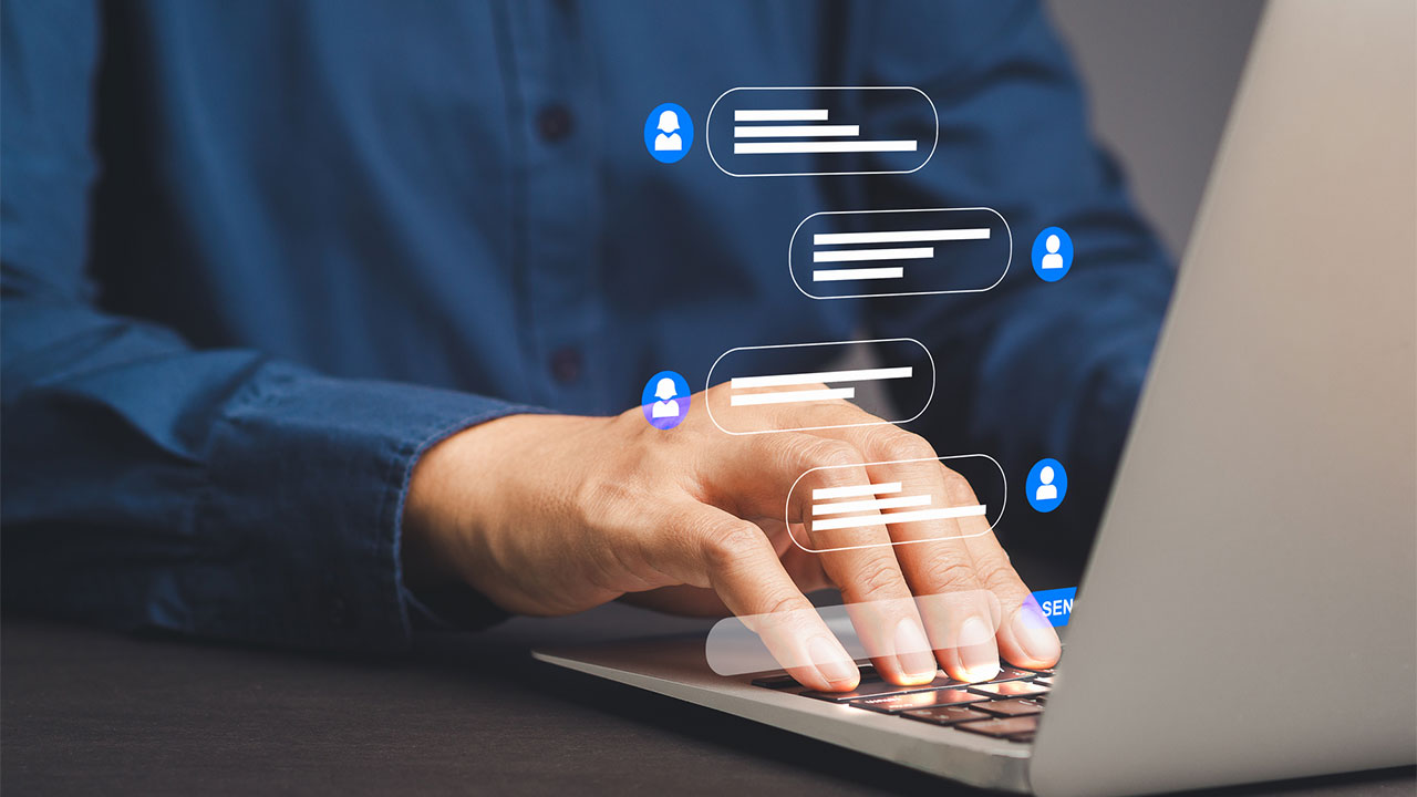 A person typing at a laptop with a generated graphic of a two-way online chat