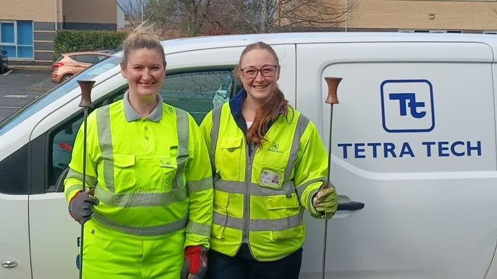 Two women stand in front of a white van with a Tetra Tech logo