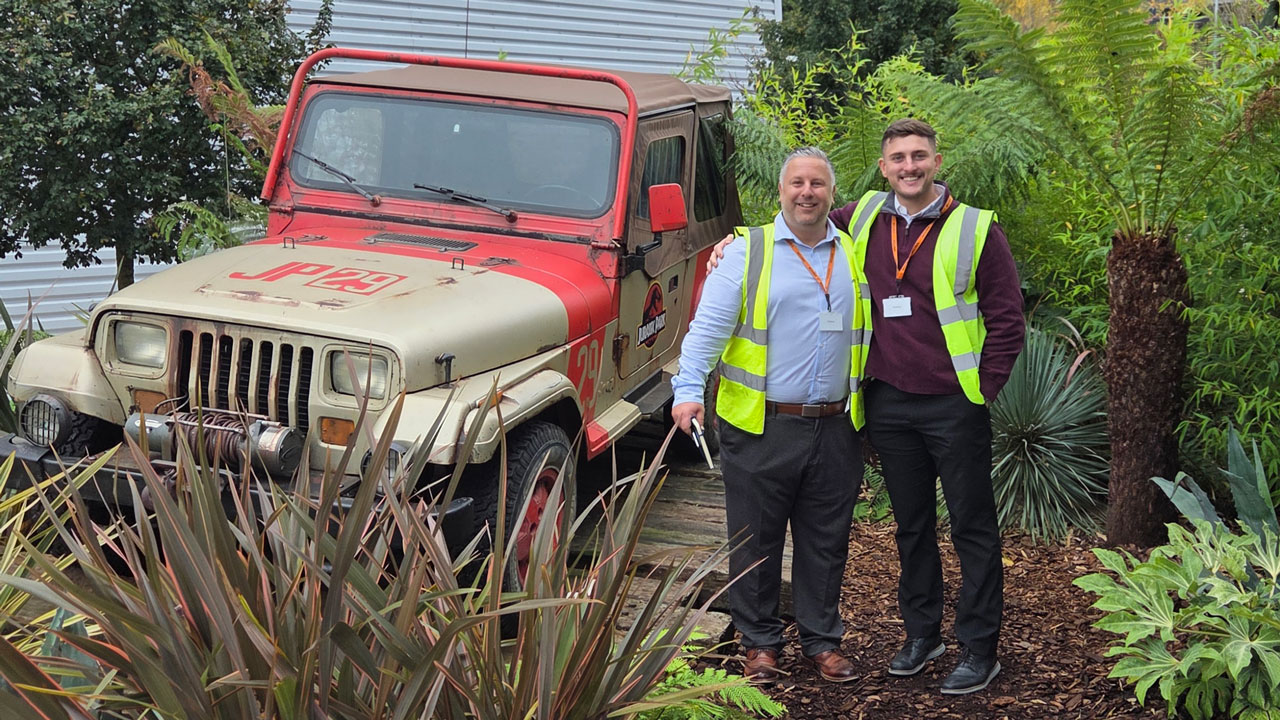Adam Shaw and a colleague stand aside a Jurassic Park Movie Prop, a Jeep, on site with one of our clients