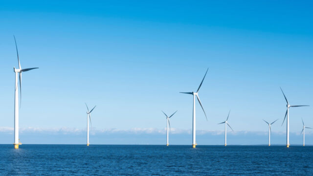 Nine fixed foundation wind turbines in a calm sea