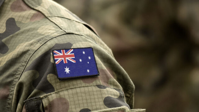 Australian flag badge on the shoulder of a person wearing camouflage
