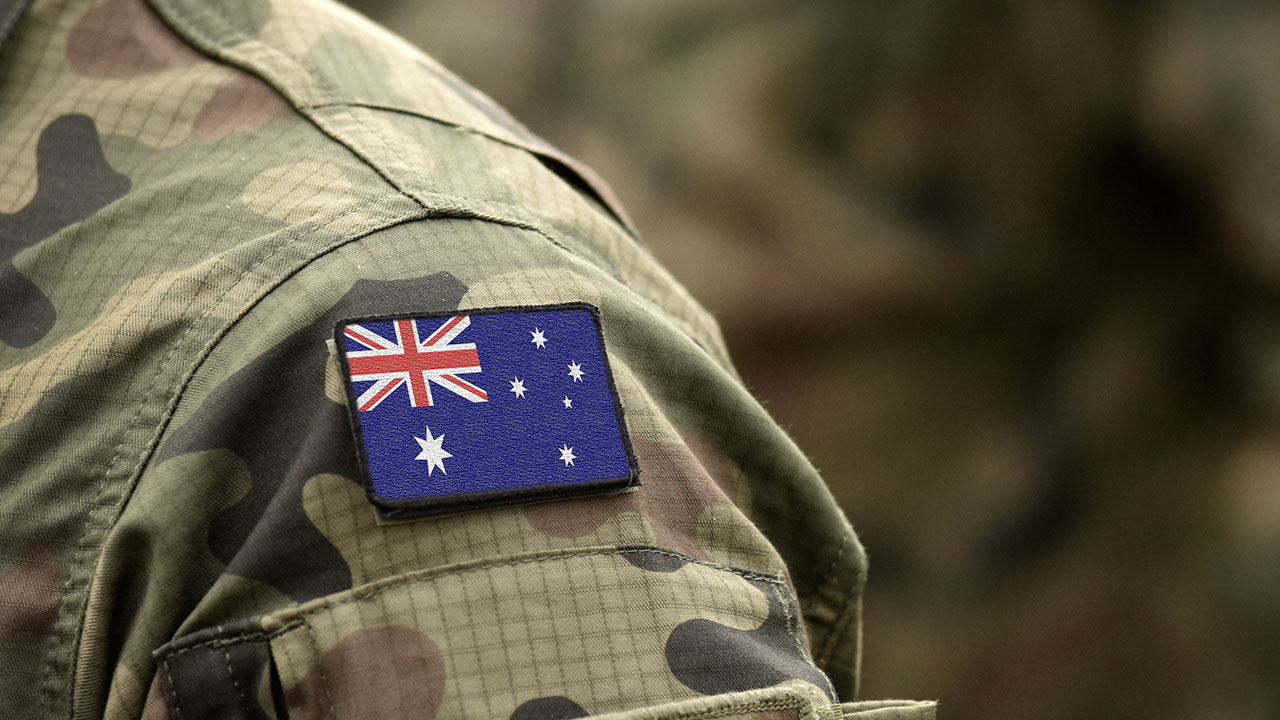 Australian flag badge on the shoulder of a person wearing camouflage