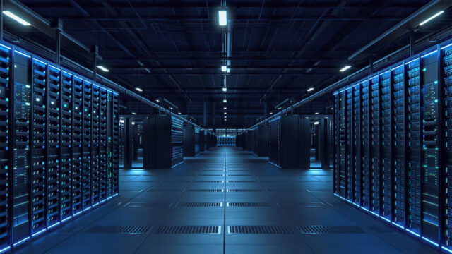 Rows of illuminated server racks line a modern data center aisle